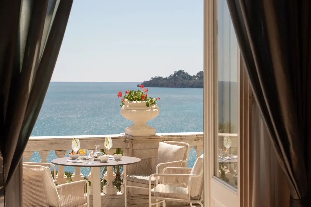 Une table est dressée sur une terrasse avec vue sur la mer.