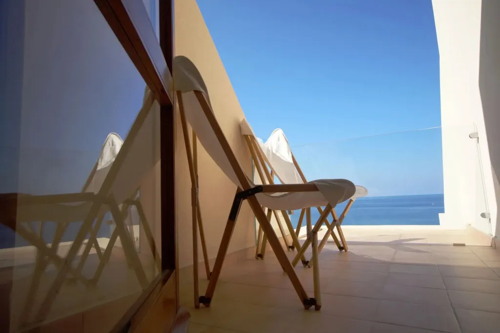 Transats alignés sur une terrasse ensoleillée avec vue sur la mer.