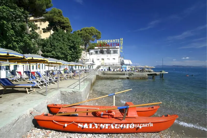 Une plage ensoleillée avec des transats et des kayaks au premier plan.