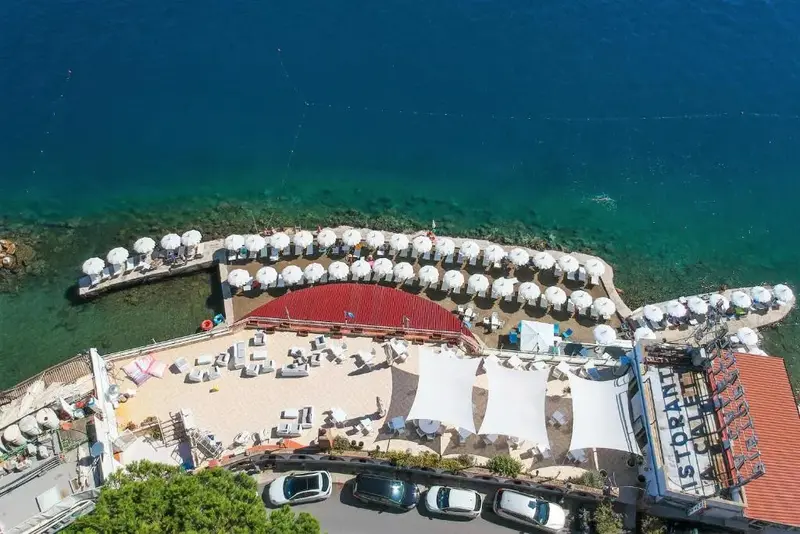 Vue aérienne d'une plage aménagée avec des transats et des parasols.