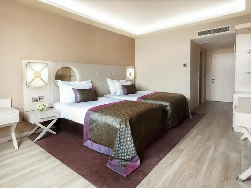 Une chambre lumineuse avec deux lits simples et une décoration moderne.