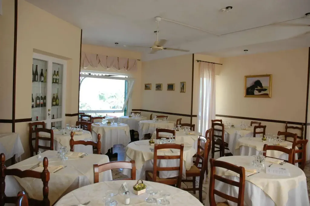 Une salle lumineuse avec des tables nappées prêtes pour le service.