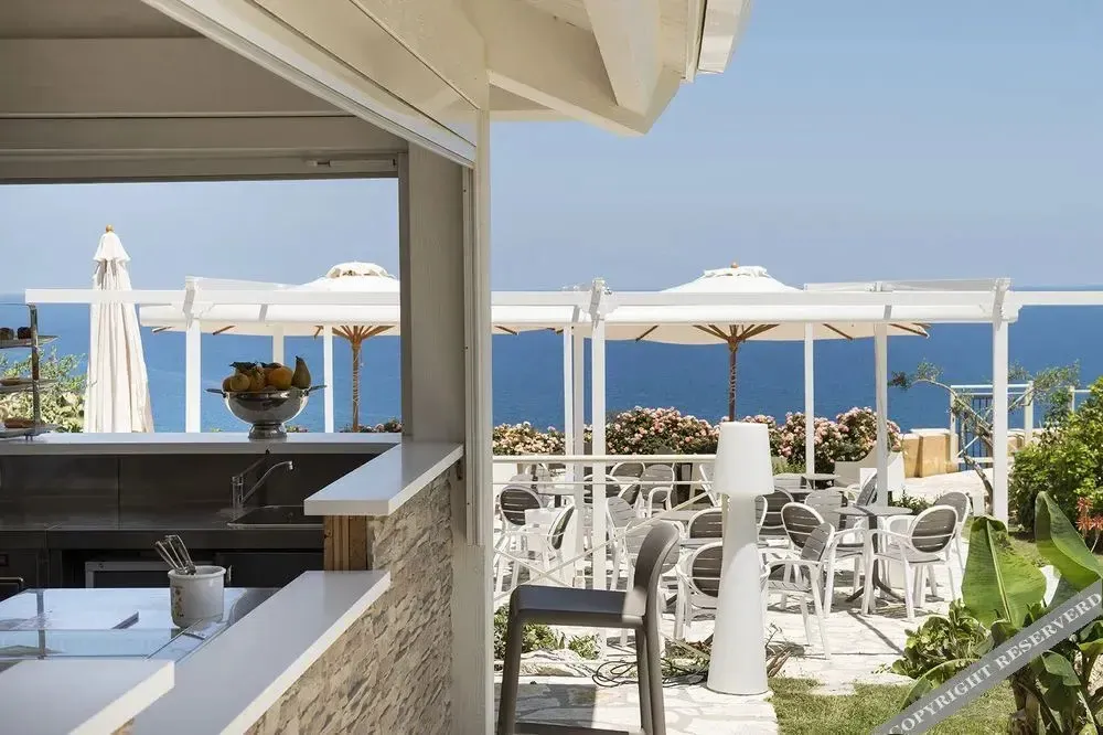 Une terrasse ombragée offre une vue sur la mer.