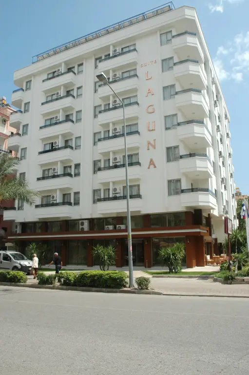 Façade d'un bâtiment blanc à plusieurs étages avec des balcons.