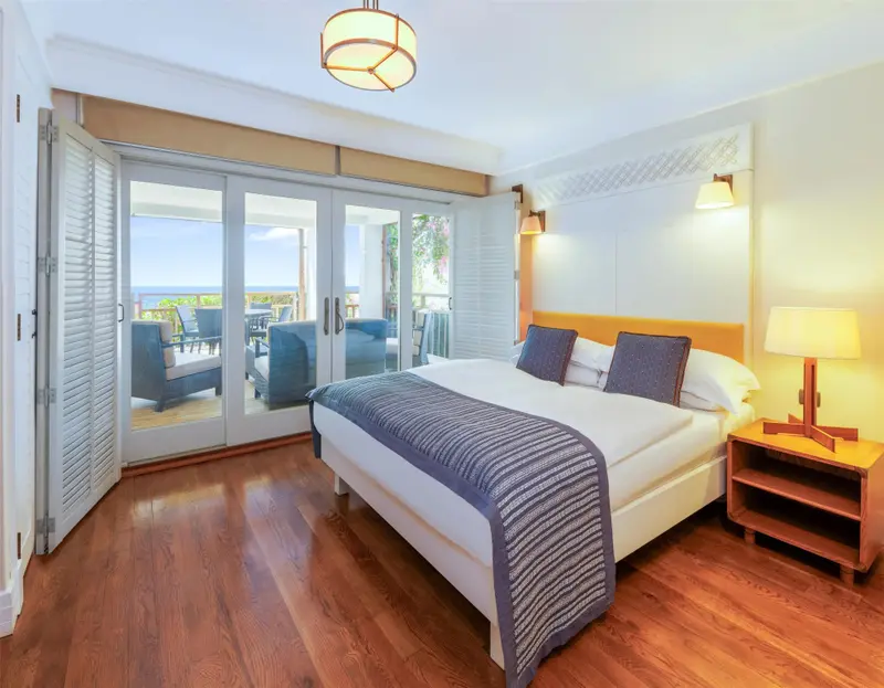 Une chambre lumineuse avec un grand lit donnant sur une terrasse.
