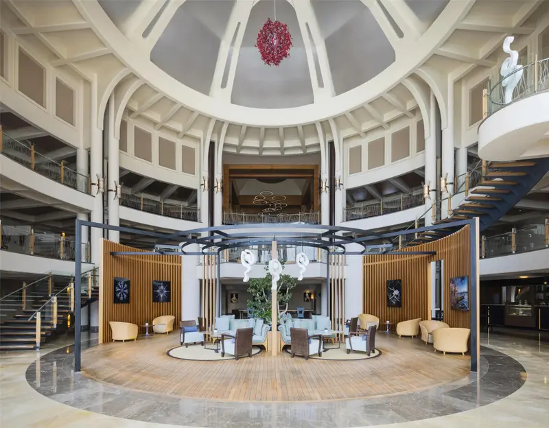 Vaste hall d'accueil avec un éclairage central original et des espaces de détente.