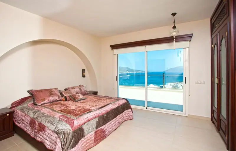 Une chambre lumineuse avec un grand lit et une vue sur la mer.