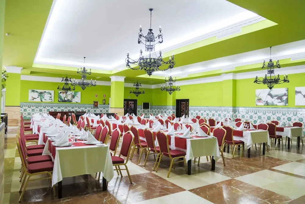 Une salle lumineuse avec des tables dressées pour un repas.