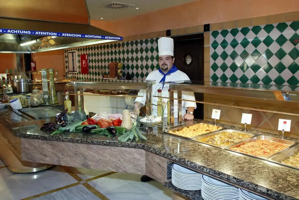 Un buffet propose une variété de plats chauds et de légumes frais.
