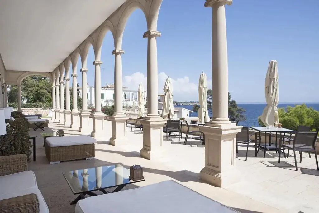 Terrasse ombragée avec mobilier de détente et tables à manger en bord de mer.