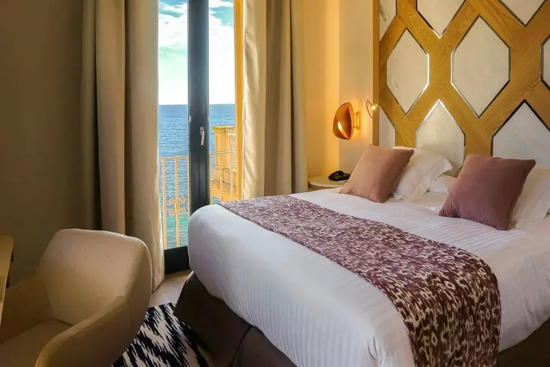 Une chambre lumineuse avec un grand lit et une vue sur la mer.