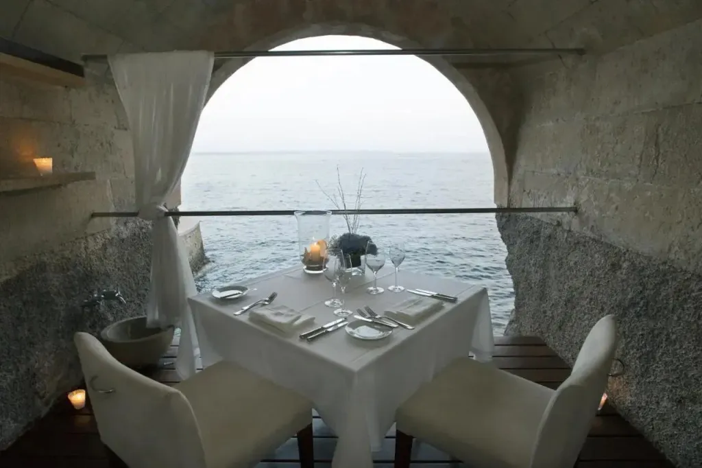 Table dressée dans une alcôve donnant sur la mer.