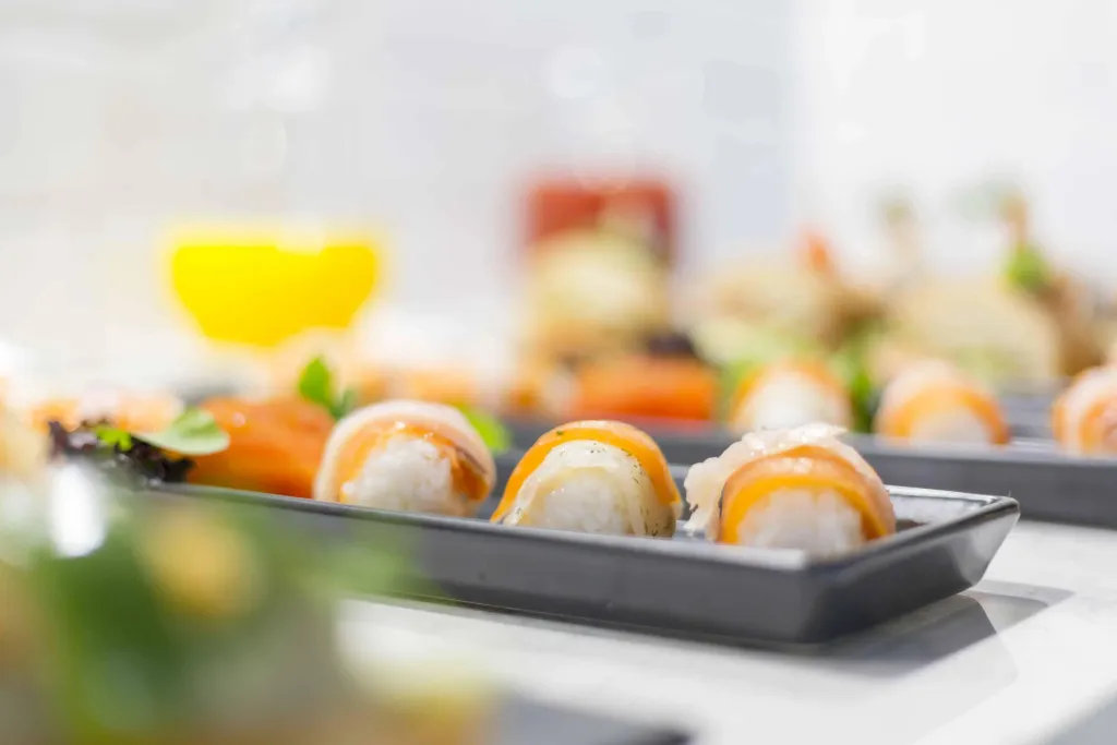 Assortiment de sushis présentés sur des plats rectangulaires.