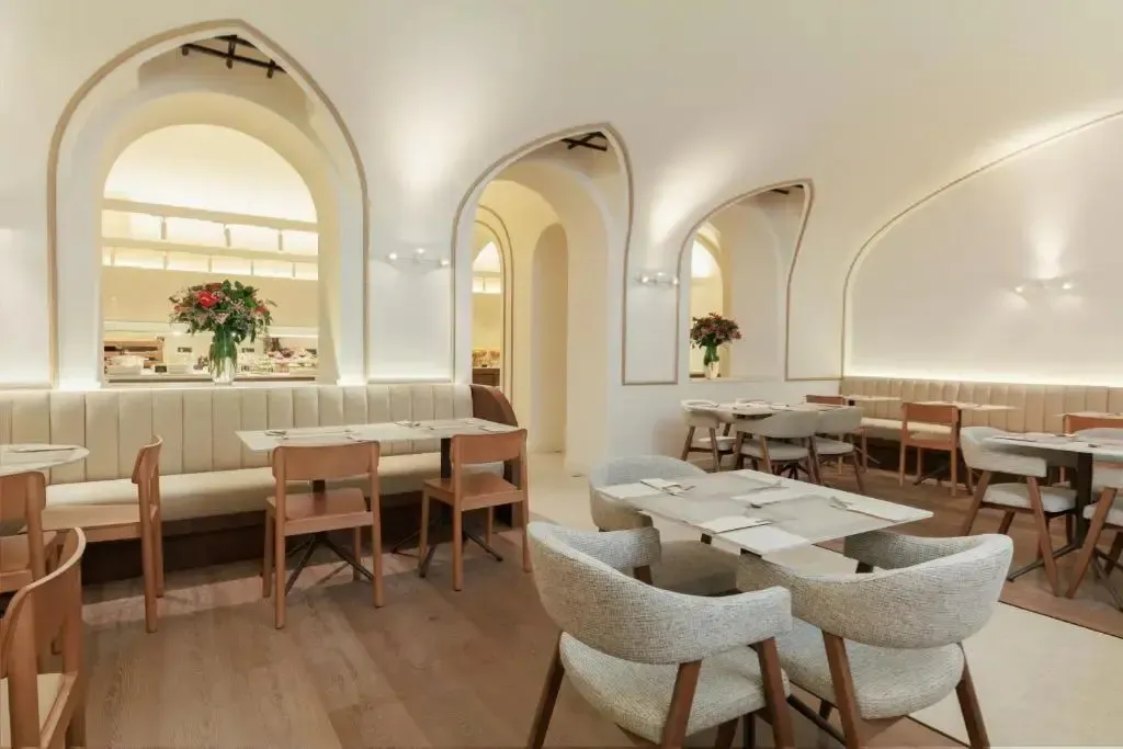 Une salle lumineuse avec des tables et des chaises disposées pour les repas.