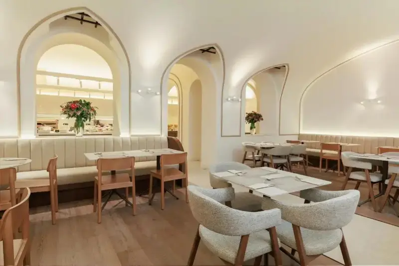 Une salle lumineuse avec des tables et des chaises disposées pour les repas.