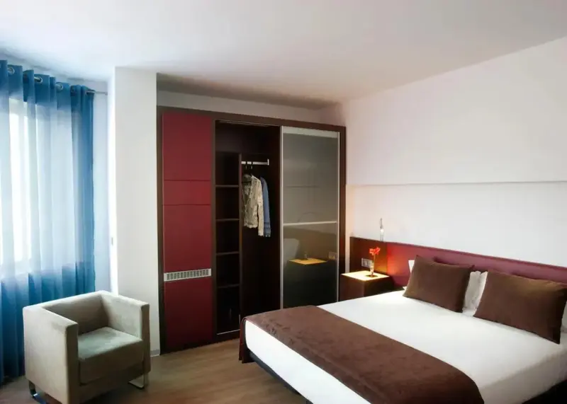 Une chambre moderne avec un lit et un fauteuil.