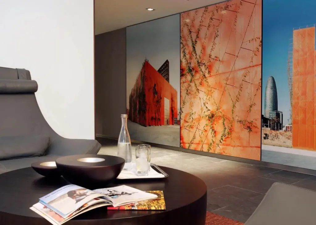 Un espace de détente intérieur avec un canapé et une table basse devant des œuvres d'art murales.