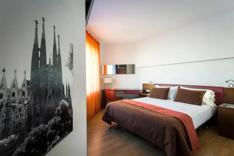 Une chambre d'hôtel moderne avec un grand lit et une décoration sobre.