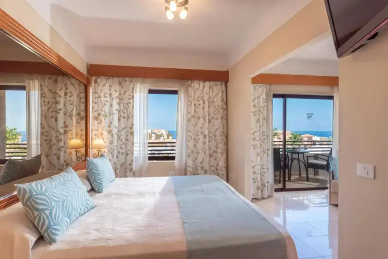 Une chambre lumineuse avec un grand lit donnant sur une terrasse.