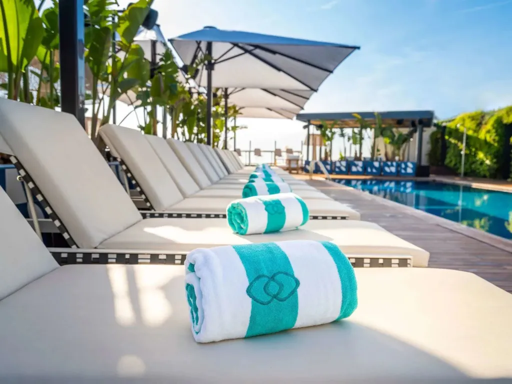 Transats alignés au bord d'une piscine ensoleillée.