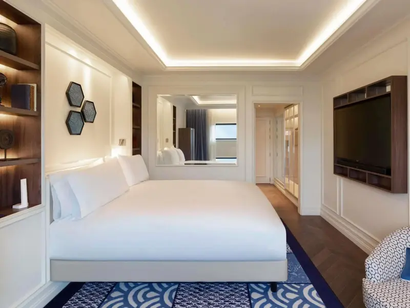 Une chambre lumineuse avec un grand lit et un miroir.