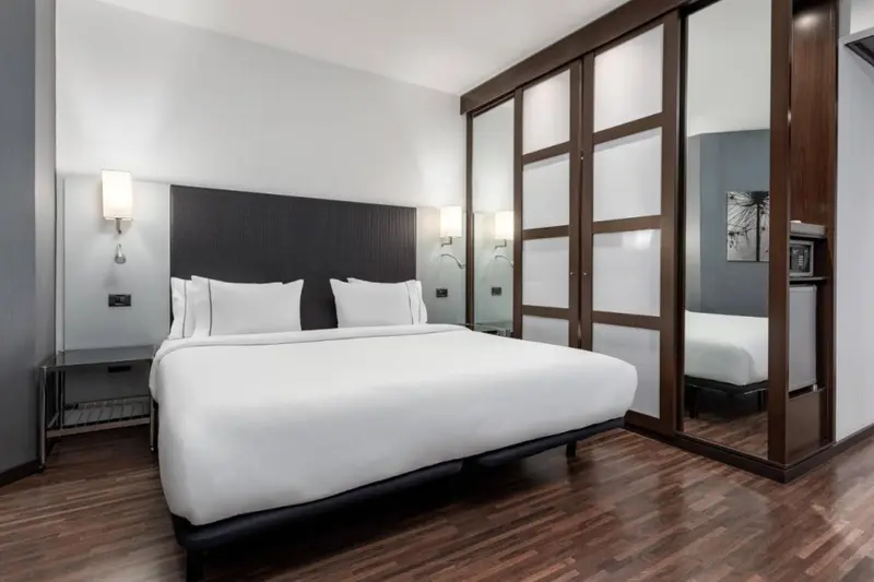 Une chambre moderne avec un grand lit et un placard en bois.