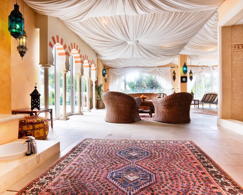Espace de détente lumineux avec des fauteuils en rotin et un décor oriental.
