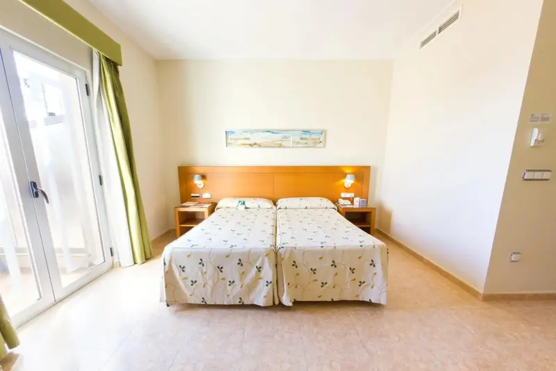 Une chambre lumineuse avec deux lits simples et un tableau décoratif au-dessus de la tête de lit.
