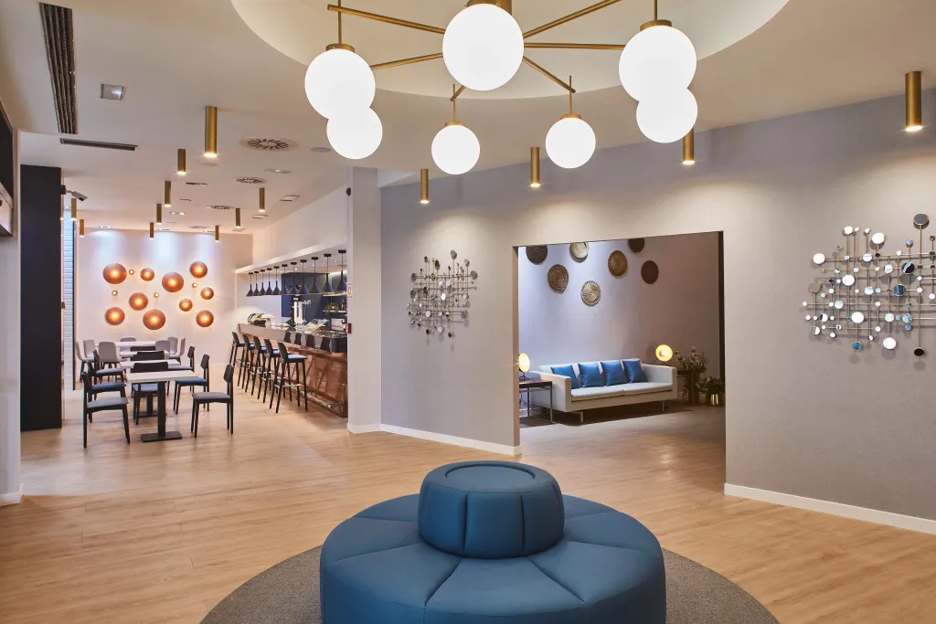 Un espace de détente avec un canapé circulaire bleu et un bar en arrière-plan.
