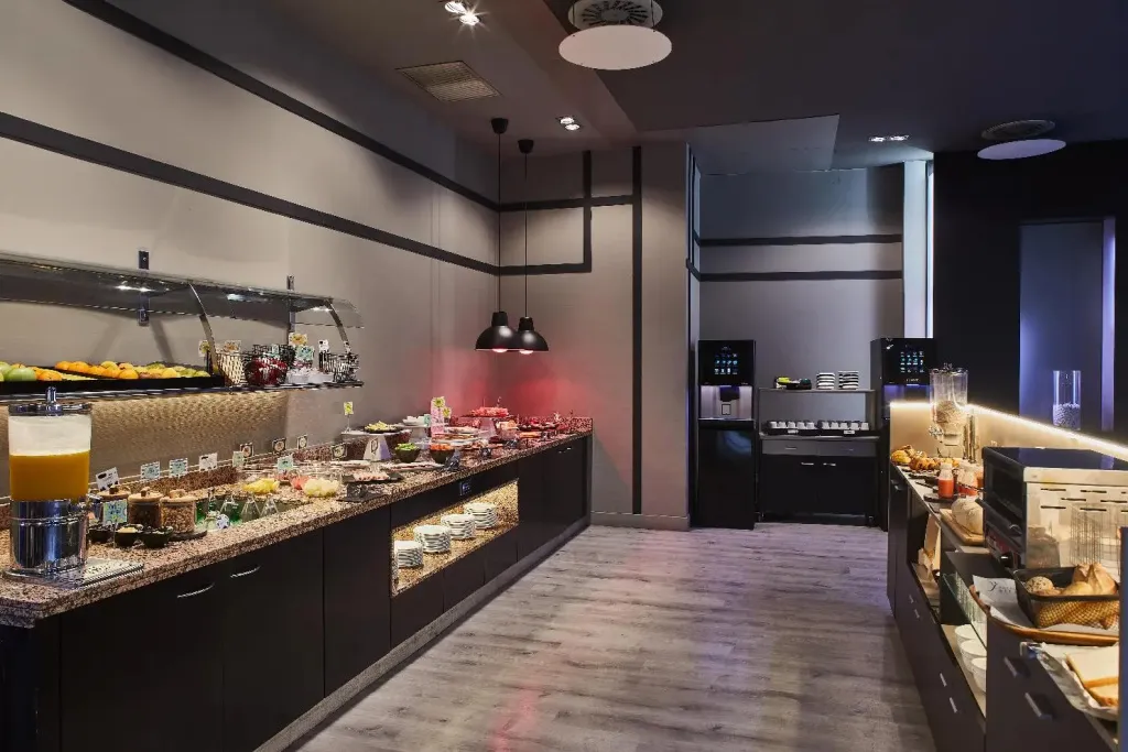 Un buffet propose une variété de plats et de boissons dans une salle lumineuse.