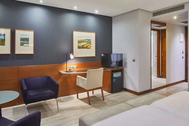 Une chambre d'hôtel moderne avec un coin salon et un bureau.