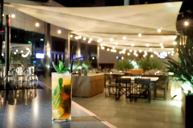 Un cocktail rafraîchissant est présenté sur un comptoir de bar éclairé.