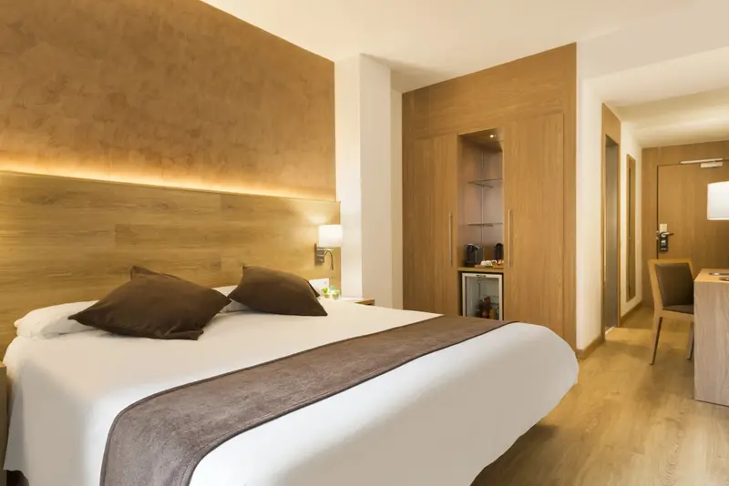 Une chambre lumineuse avec un grand lit et un espace détente.