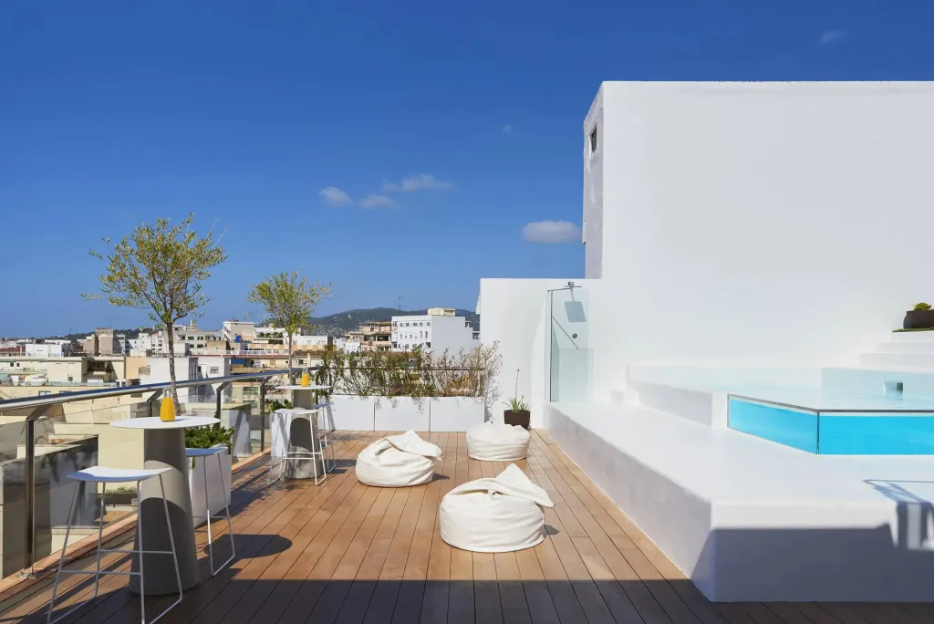 Terrasse aménagée avec mobilier d'extérieur et petite piscine, vue sur la ville.