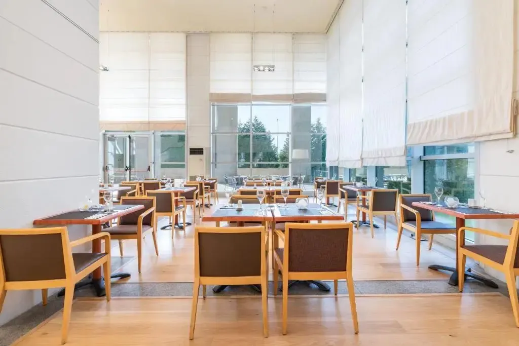 Une salle lumineuse avec des tables dressées pour un repas.