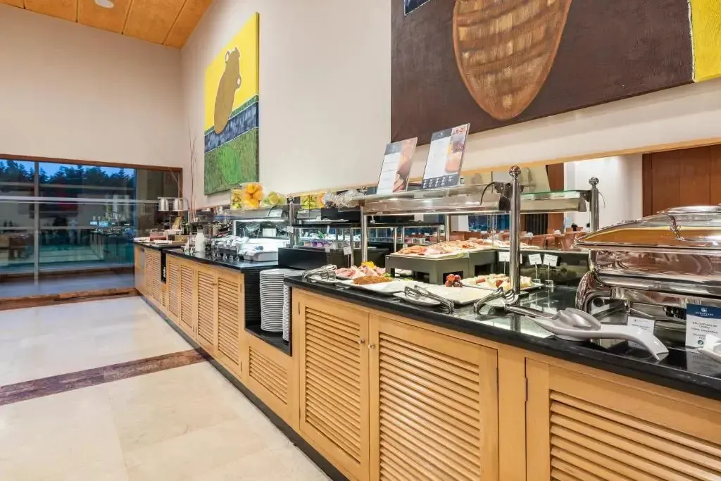 Un buffet propose une variété de plats et de boissons dans une salle lumineuse.