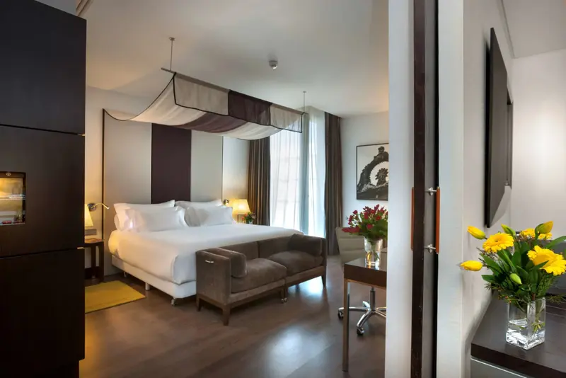 Une chambre lumineuse avec un grand lit et un coin salon.