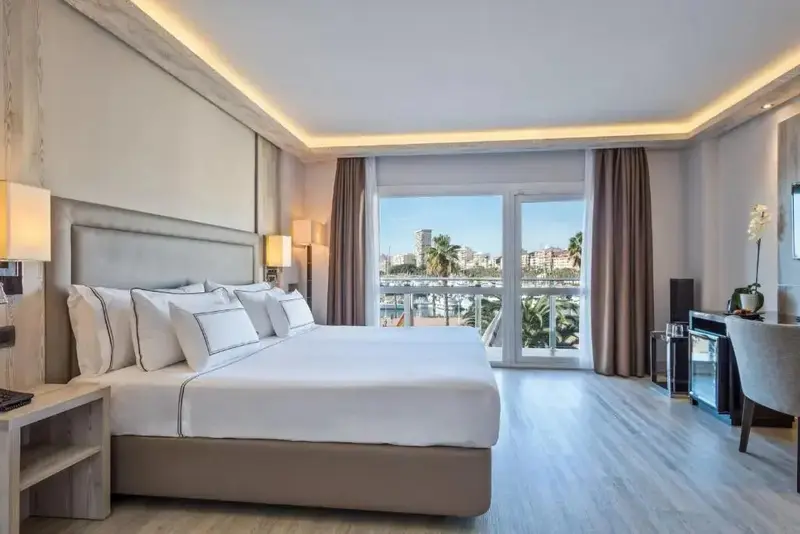 Une chambre lumineuse avec un grand lit et un accès à une terrasse.