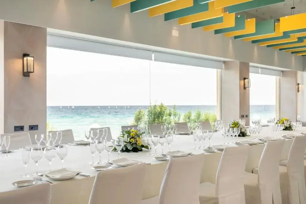 Une salle lumineuse avec de grandes baies vitrées donnant sur la mer.
