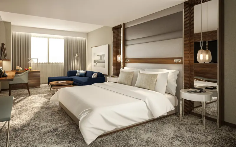 Une chambre lumineuse avec un grand lit et un coin salon.