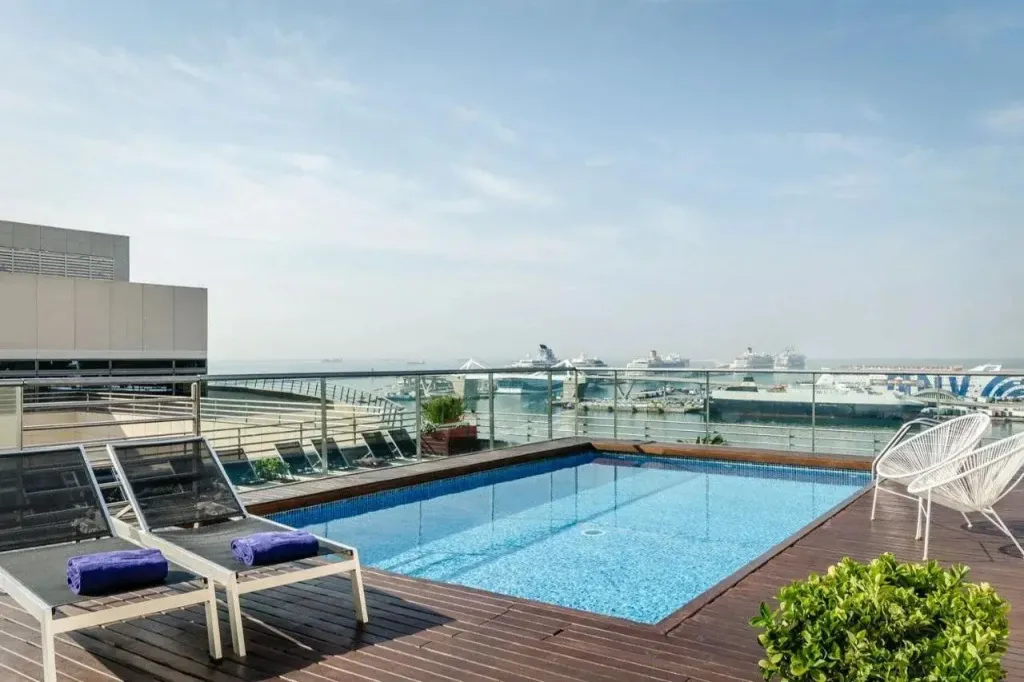 Terrasse avec piscine et vue sur un port de plaisance.