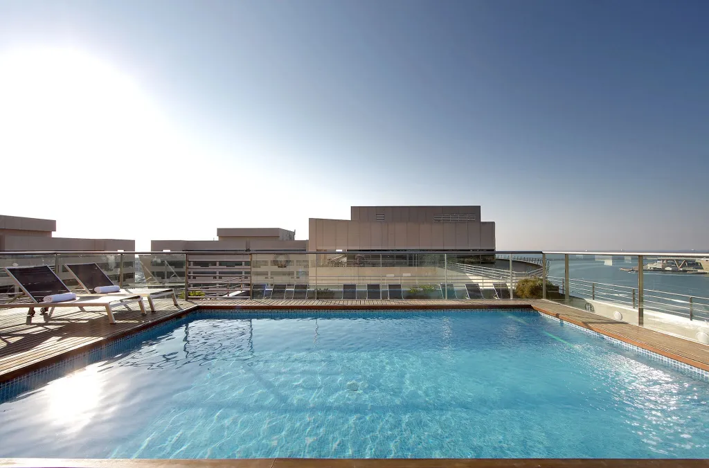 Une piscine sur le toit d'un bâtiment avec une vue sur la mer.