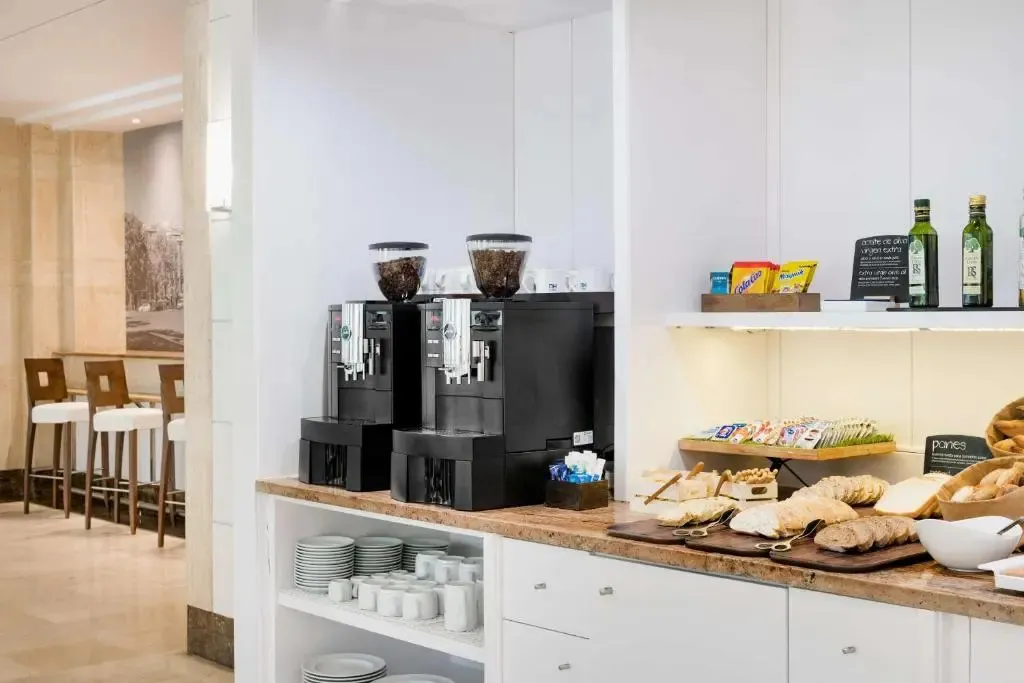 Un comptoir propose des viennoiseries, des boissons chaudes et des condiments.