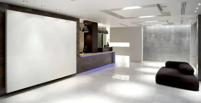 Un comptoir d'accueil moderne dans un espace lumineux et minimaliste.