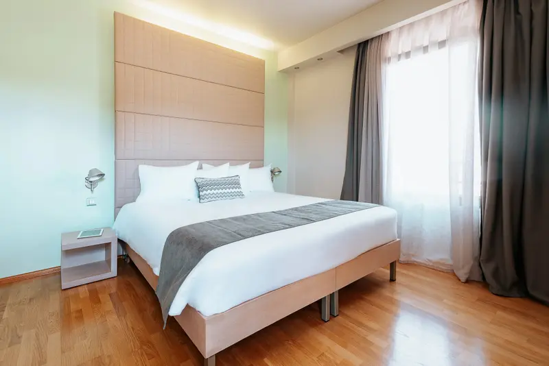 Une chambre lumineuse avec un grand lit et des rideaux.