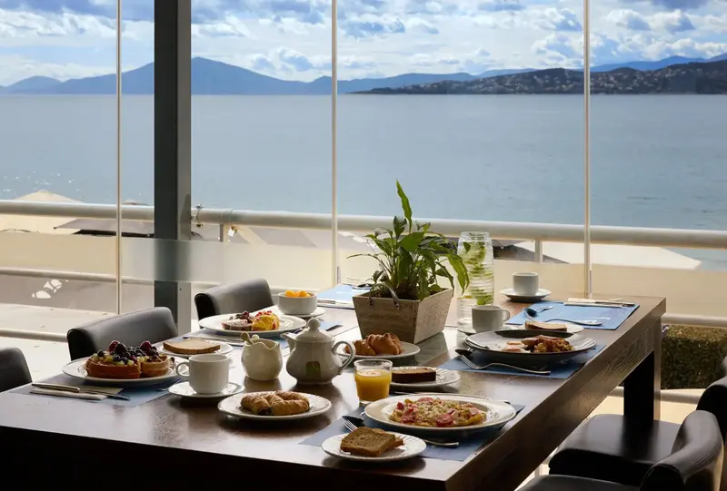 Une table est dressée pour le petit-déjeuner avec vue sur la mer.