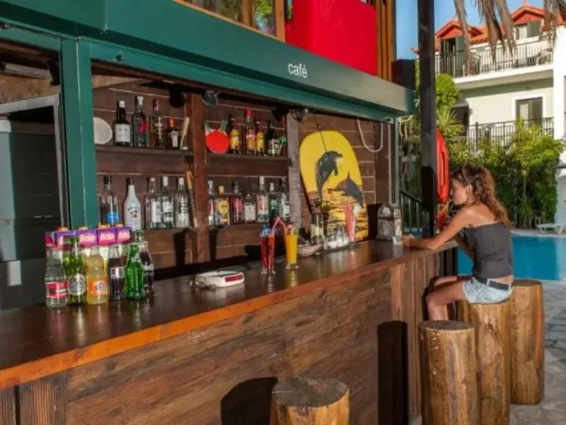 Un bar extérieur propose des boissons et des cocktails près d'une piscine.