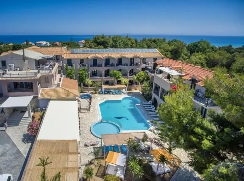 Vue aérienne d'un complexe hôtelier avec piscine et végétation luxuriante.