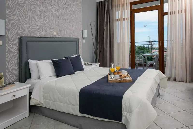Une chambre lumineuse avec un grand lit et un plateau de petit-déjeuner.
