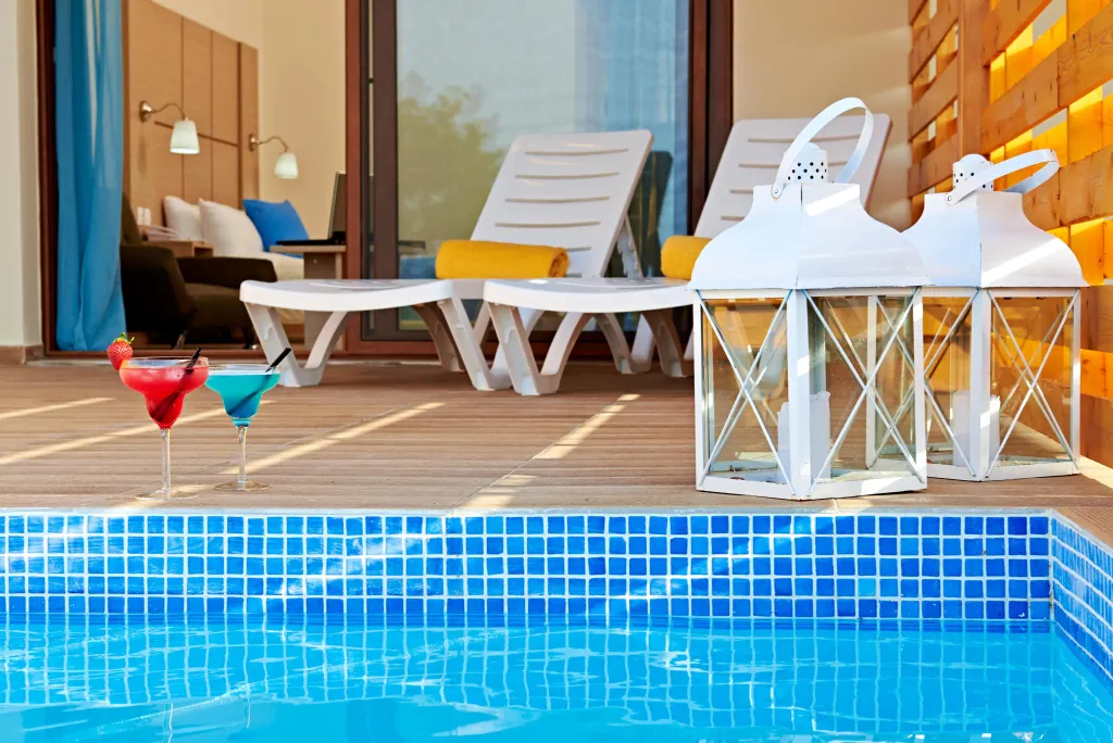 Transats et cocktails au bord d'une piscine turquoise.